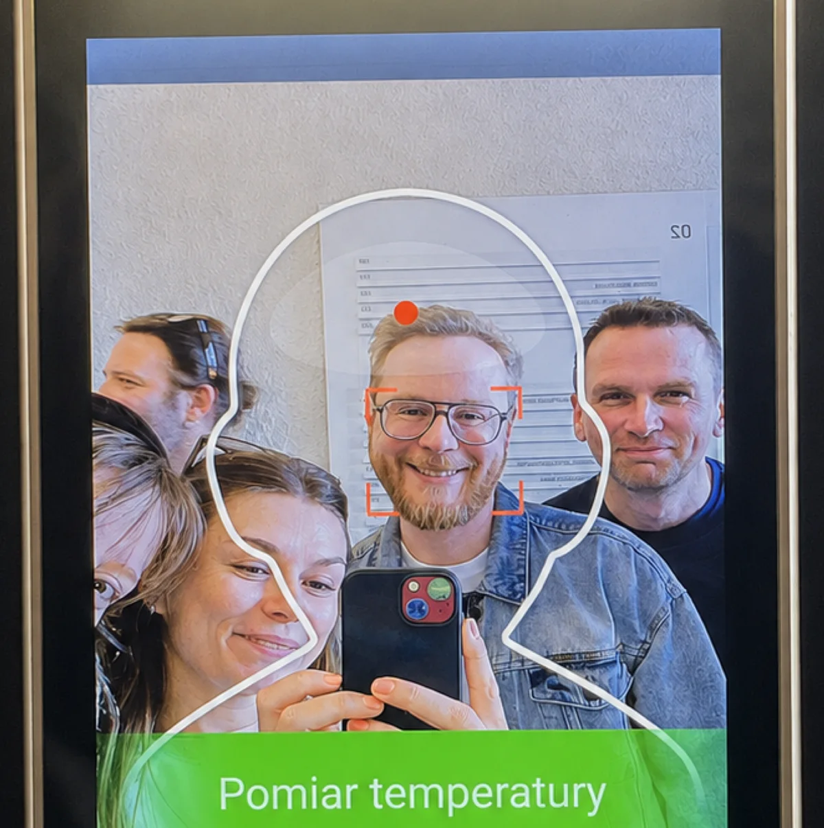 Das Team spiegelt sich im Display eines Zutrittsscanners